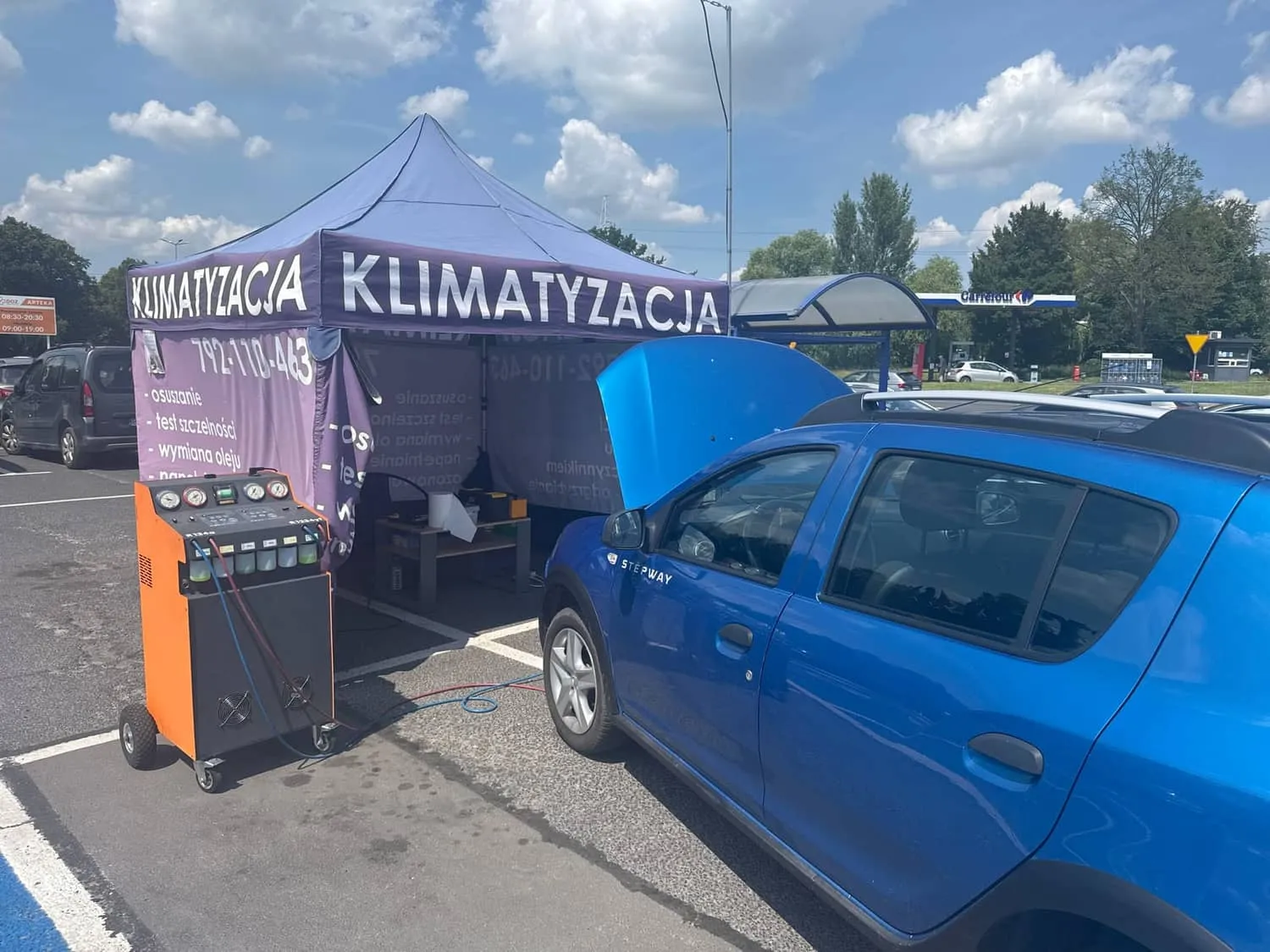 Niebieska Dacia Sandero Stepway na serwisie klimatyzacji na parkingu przy Carrefour w Pabianicach