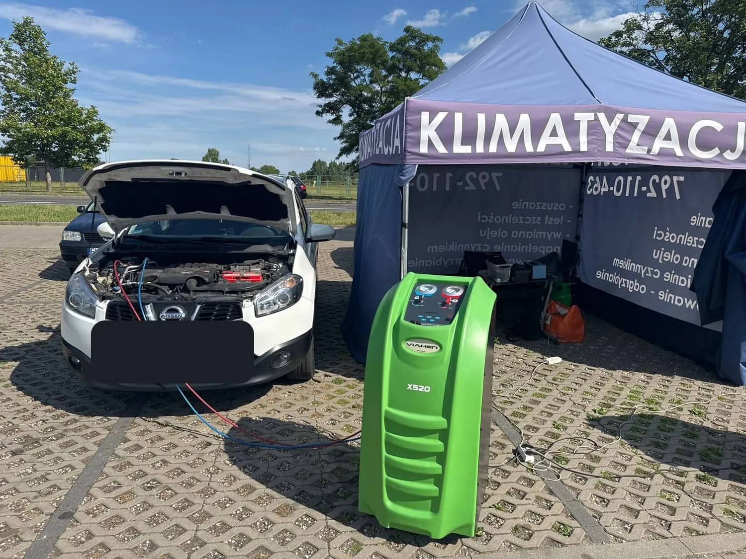 Biały Nissan Qashqai z otwartą maską podczas nabicia klimatyzacji w punkcie Klima w Aucie w Kutnie