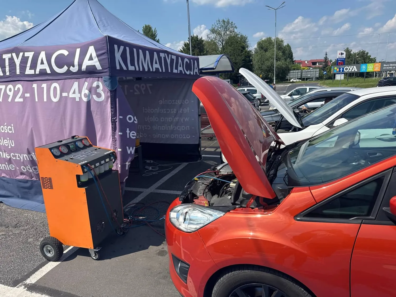 Pomarańczowe auto rodzinne z otwartą maską podczas serwisu klimatyzacji w Pabianicach