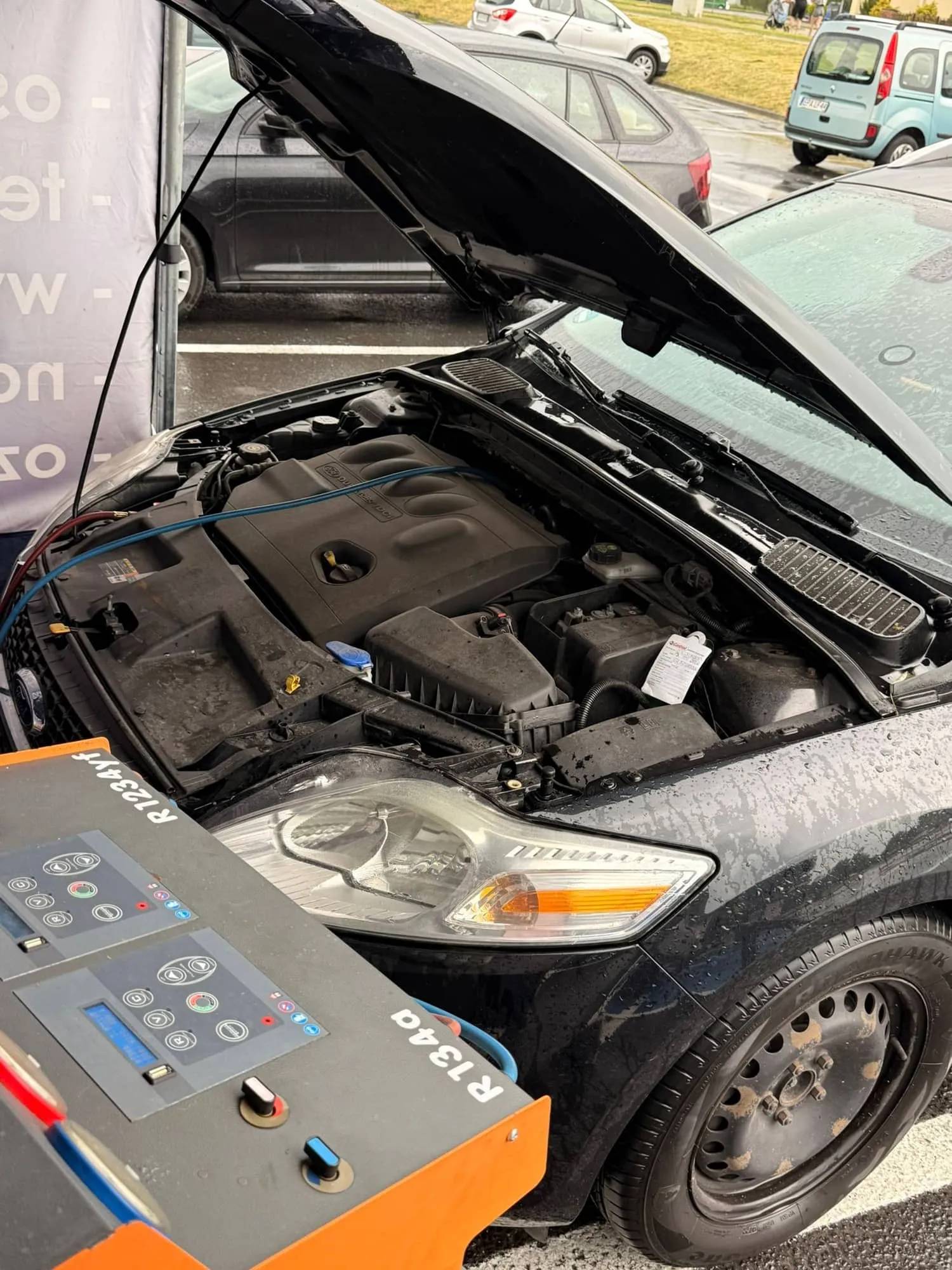 Pełny serwis klimatyzacji samochodowej, auto z otwartą maską podłączone do stacji