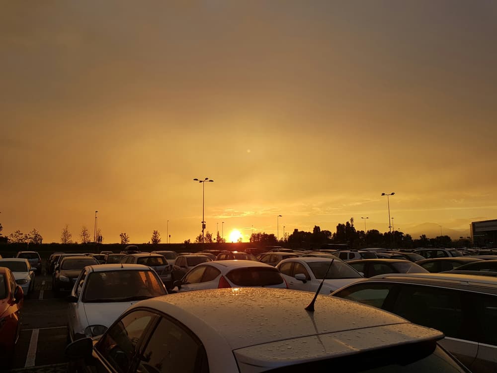 Auta zaparkowane w pełnym słońcu na rozgrzanym parkingu