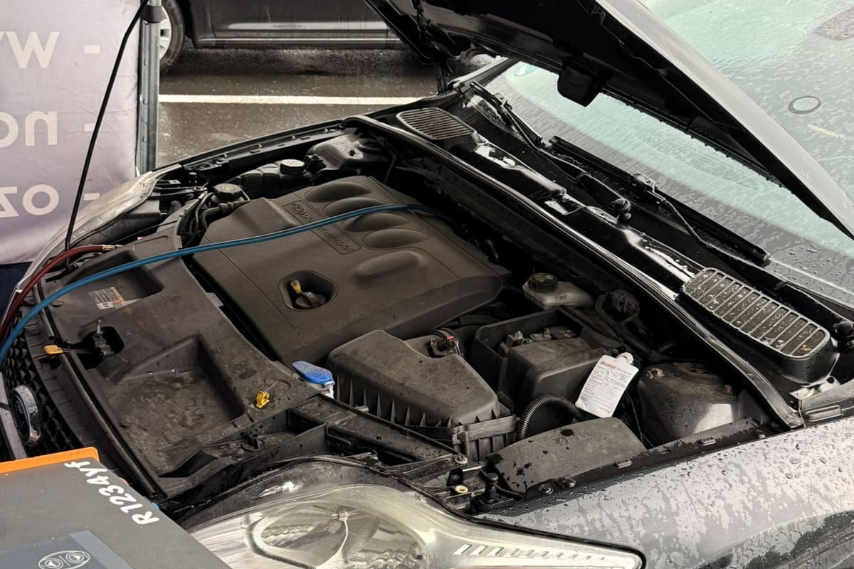 Pełny serwis klimatyzacji przy dwugazowej stacji: auto z otwartą maską i podpiętymi wężami serwisowymi