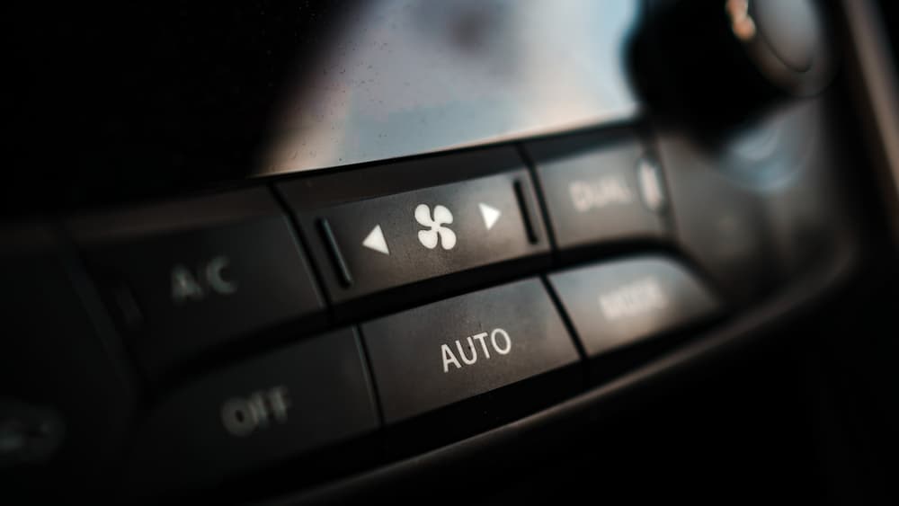 Przyciski A/C, AUTO i OFF panelu klimatyzacji z symbolem wentylatora