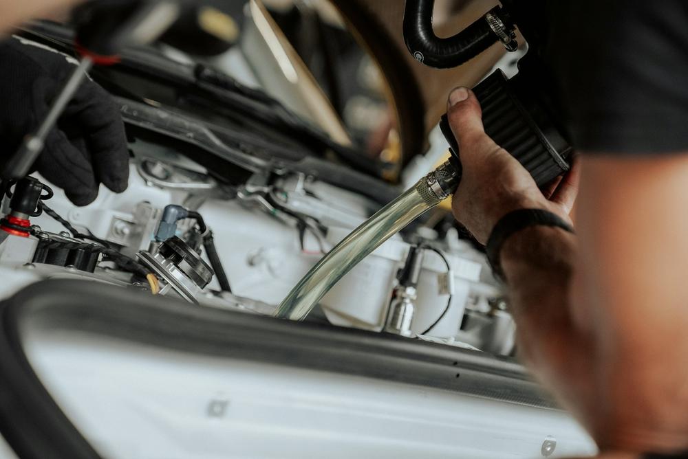 Mechanik sprawdza połączenia przewodów pod maską auta